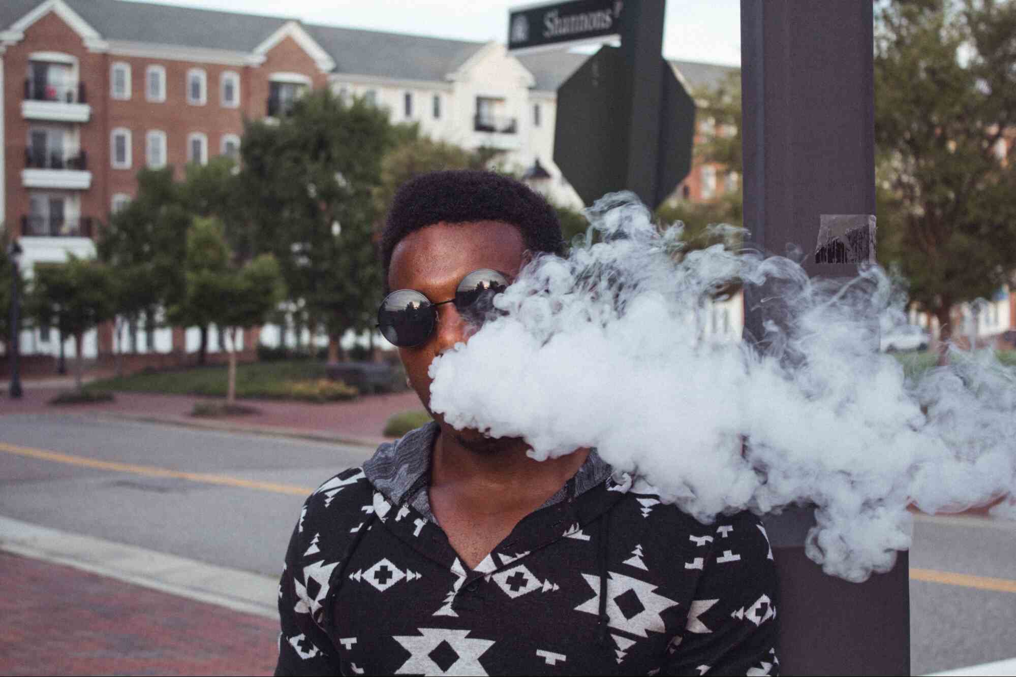 man smoking near street sign